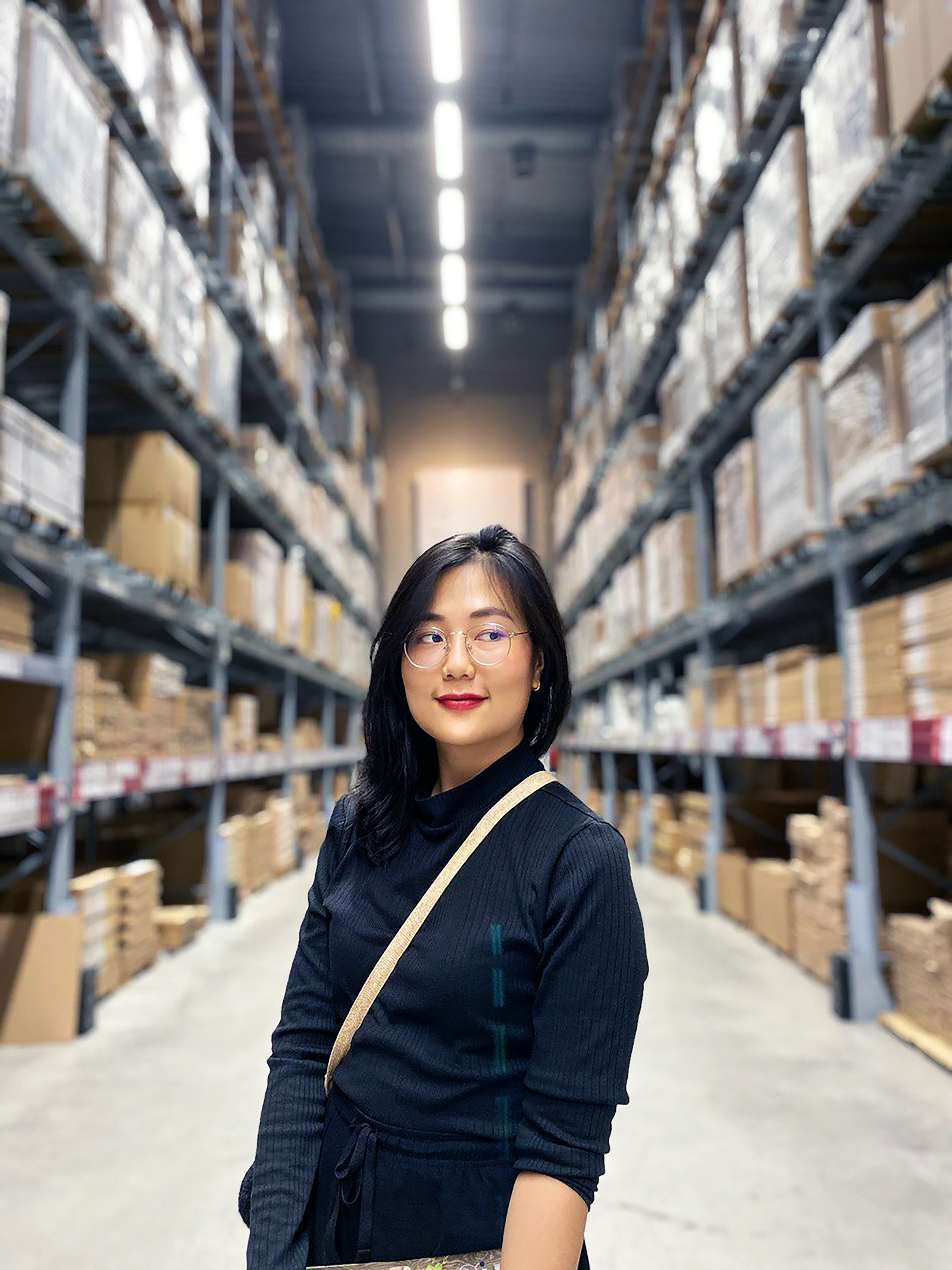 Staff member in a warehouse with shelves of boxes
