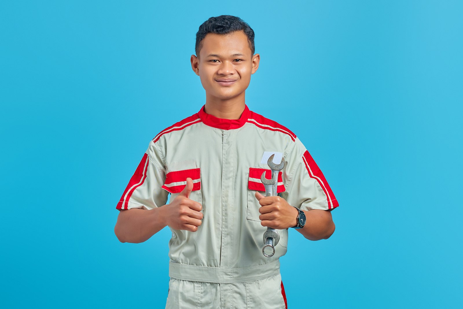Service technician in uniform holding wrenches