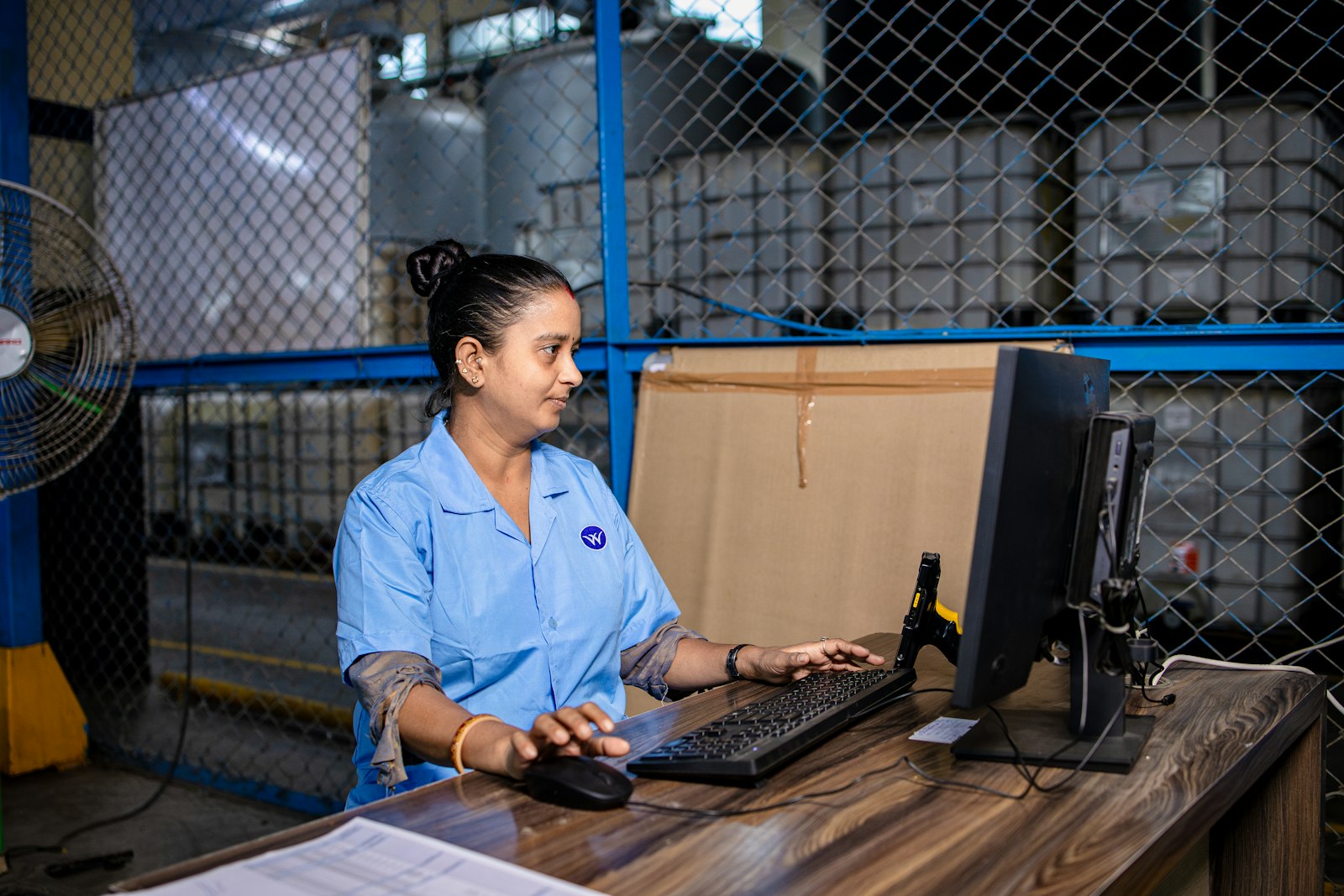 Online shop staff working at a computer in a stockroom