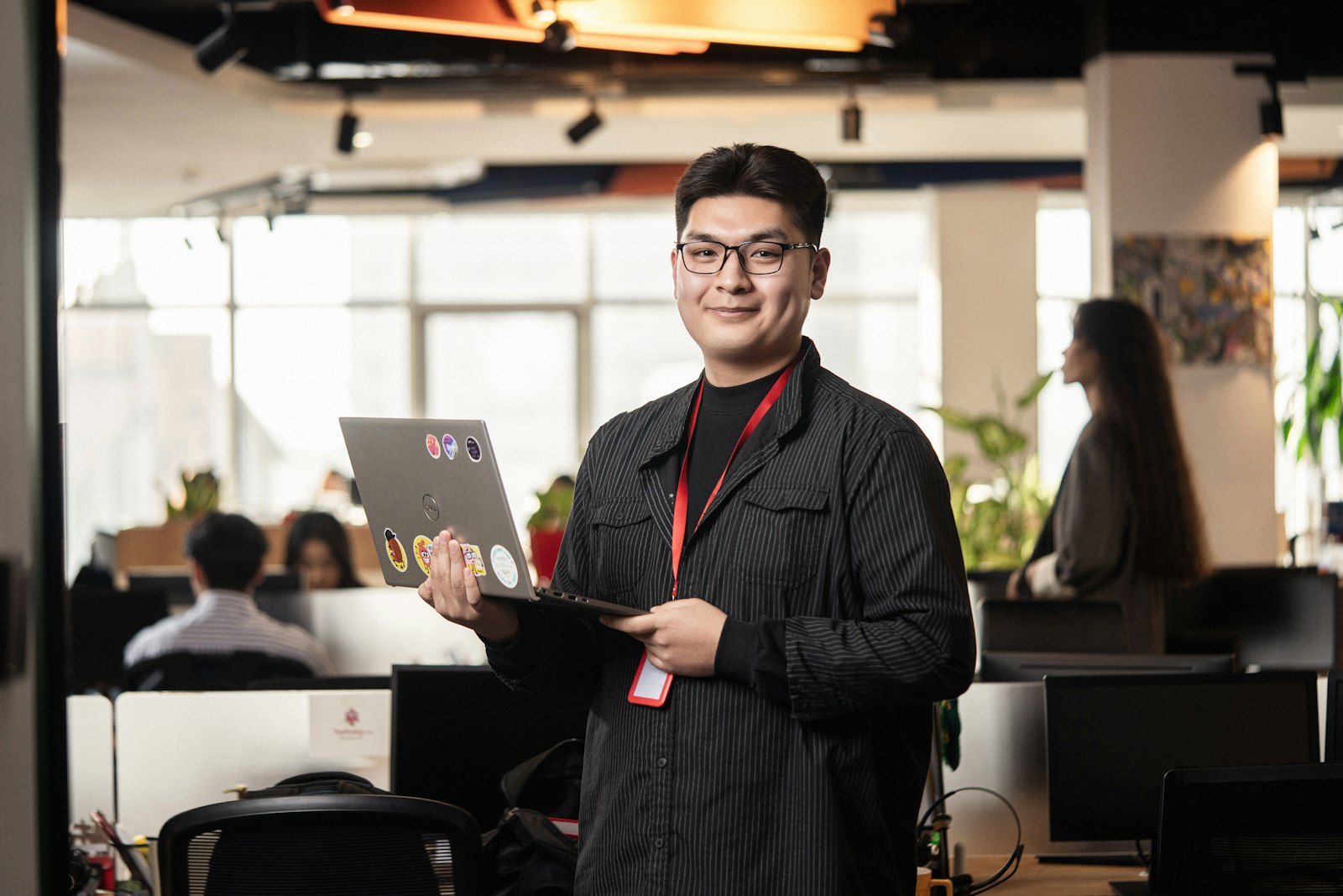 A manager holding a laptop in the office