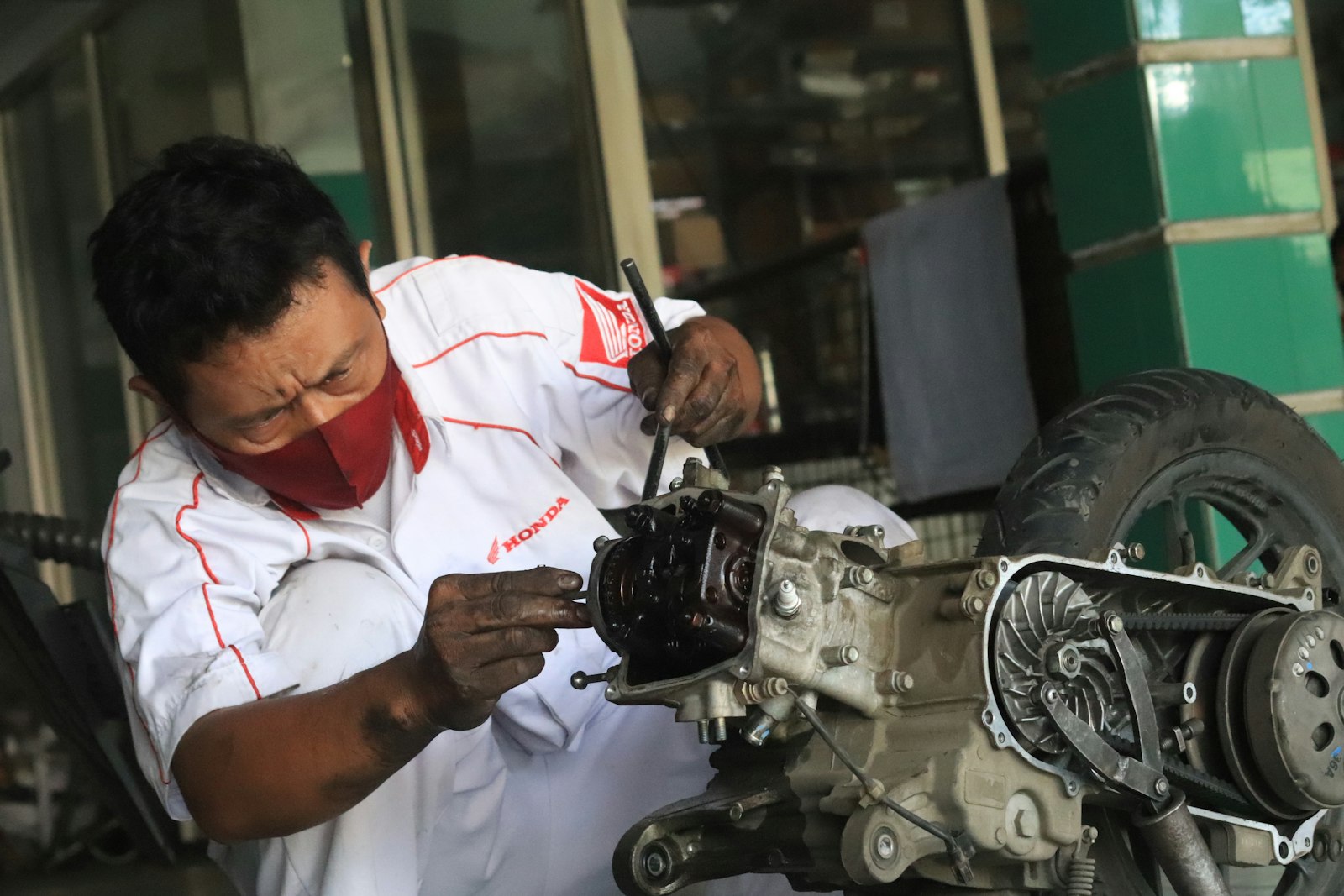 An Asian mechanic repairing a vehicle at a service centre