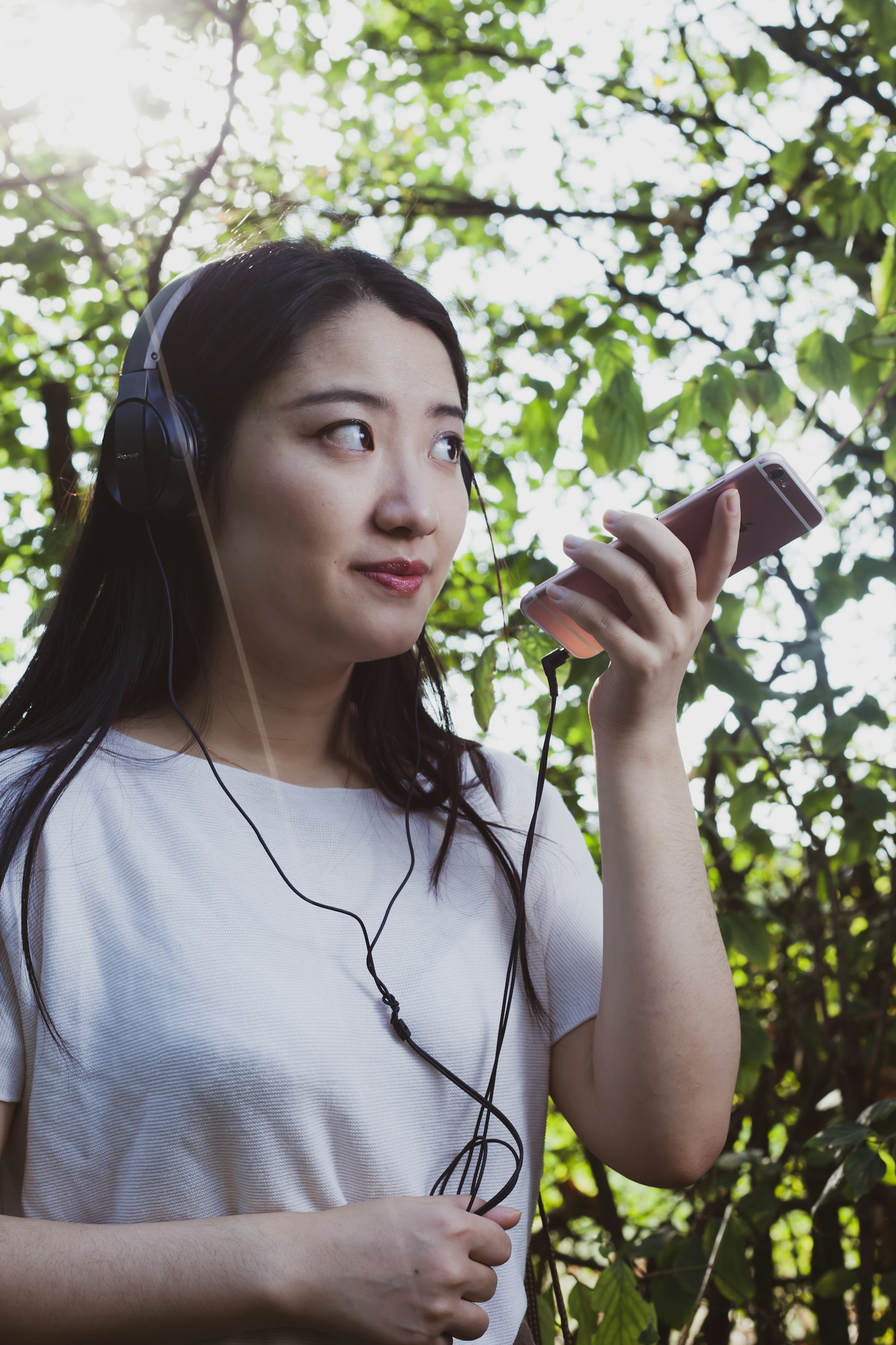 A woman with earphones holding a smartphone