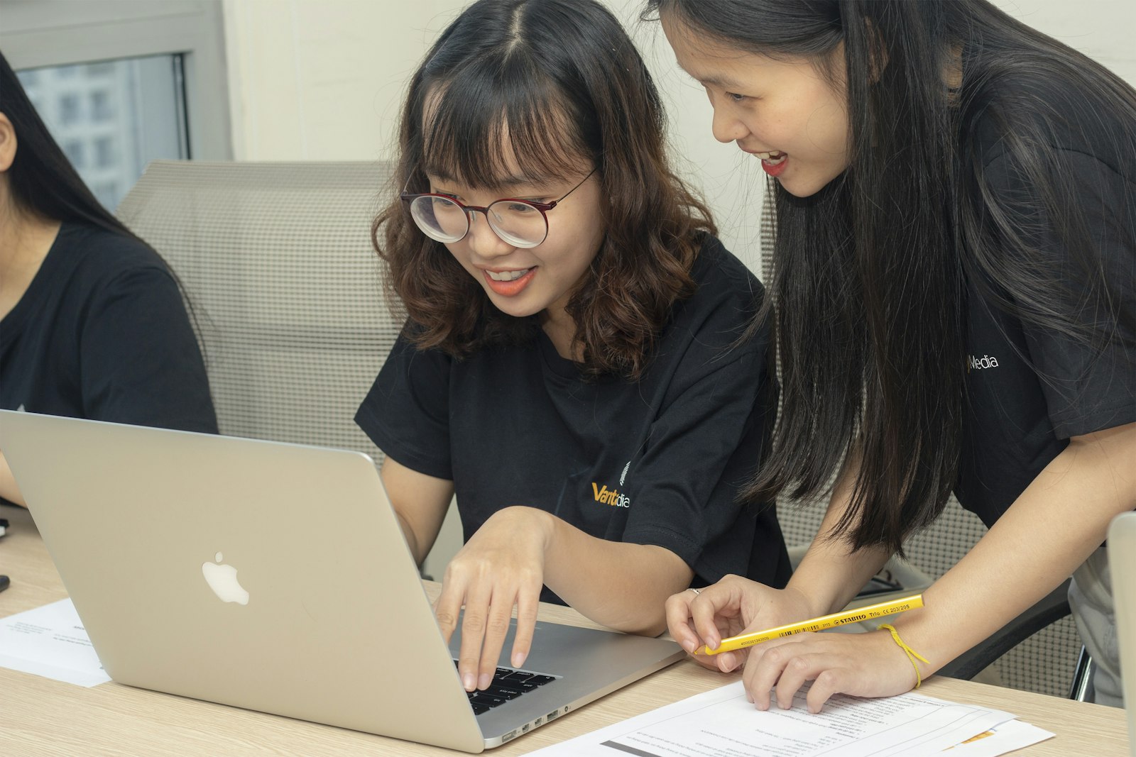 Asian women working together on laptops